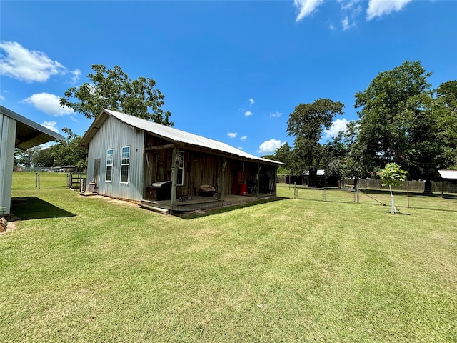 back of house with an outbuilding and a lawn