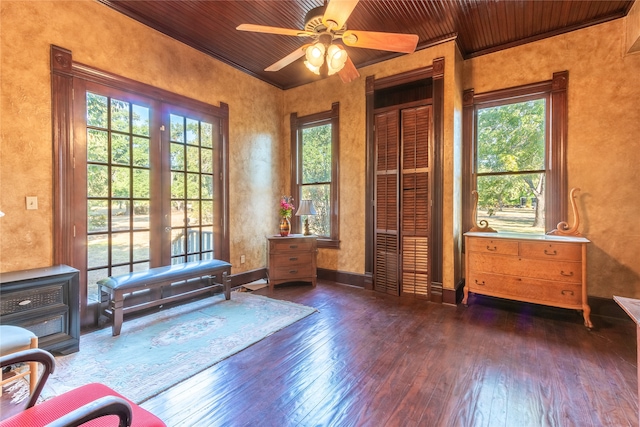 living area with dark hardwood / wood-style floors, ceiling fan, wooden ceiling, and ornamental molding