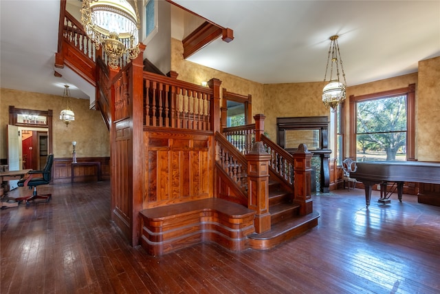 stairway featuring dark hardwood / wood-style floors and a chandelier