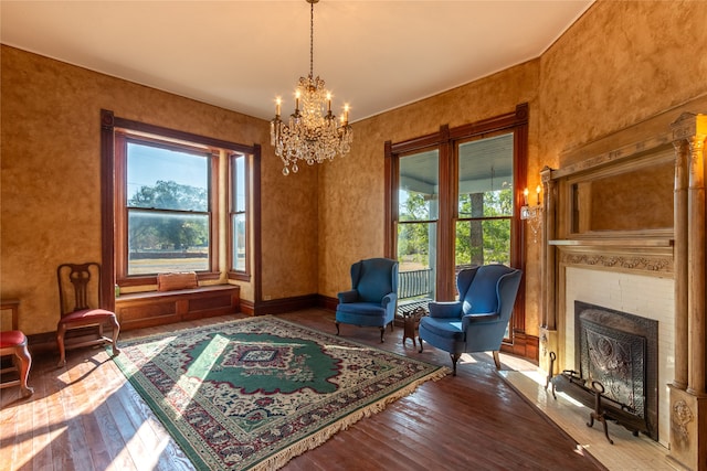 living area featuring dark wood-type flooring, a brick fireplace, and a chandelier