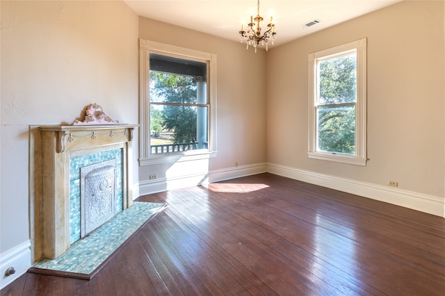 unfurnished living room featuring a premium fireplace, dark hardwood / wood-style floors, and a chandelier