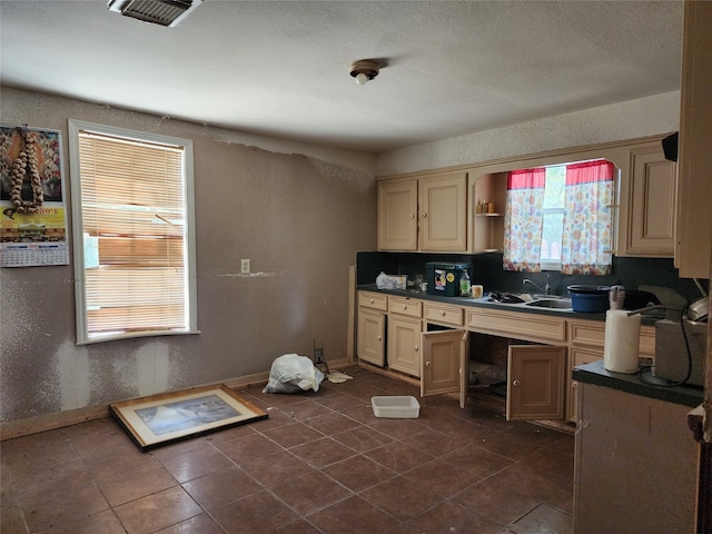 kitchen with built in desk, sink, and dark tile floors