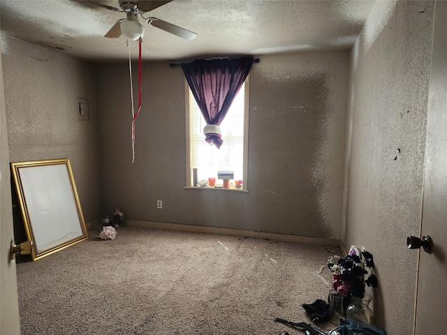 carpeted empty room with ceiling fan and a textured ceiling