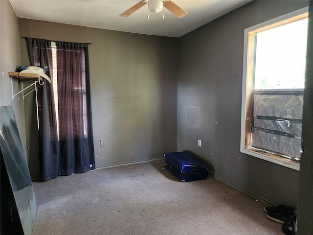 carpeted spare room featuring ceiling fan