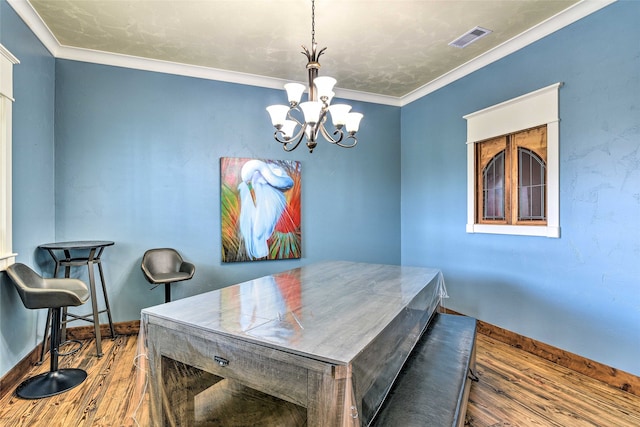 dining space with dark hardwood / wood-style flooring, crown molding, and a chandelier