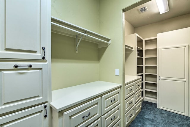 walk in closet featuring dark colored carpet