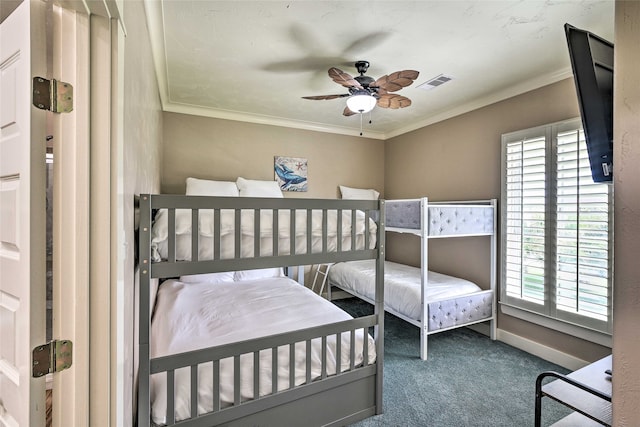 bedroom with ceiling fan, crown molding, dark colored carpet, and multiple windows