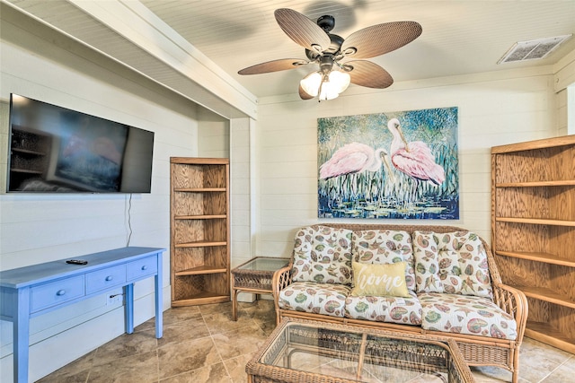 living area featuring light tile flooring and ceiling fan