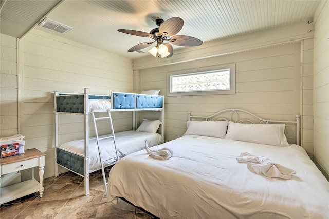 bedroom with wooden walls and ceiling fan