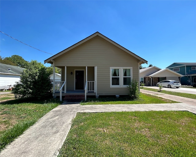 bungalow-style home with covered porch and a front yard