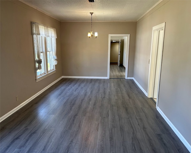 spare room with dark hardwood / wood-style flooring, a textured ceiling, ornamental molding, and a chandelier