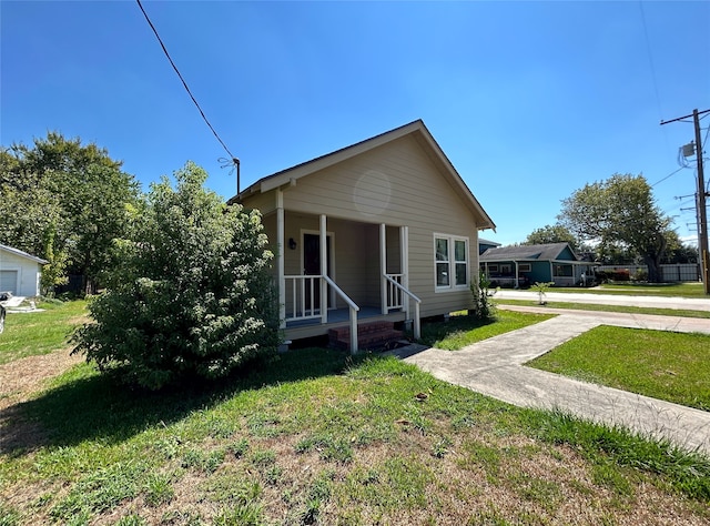 bungalow-style house with a front lawn and a porch