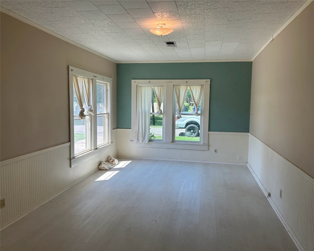 unfurnished room featuring crown molding and light wood-type flooring