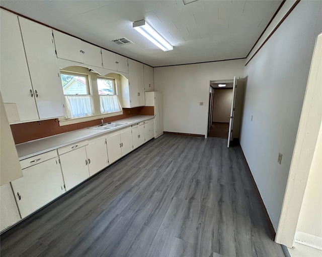 kitchen featuring white cabinets, dark wood-type flooring, and sink