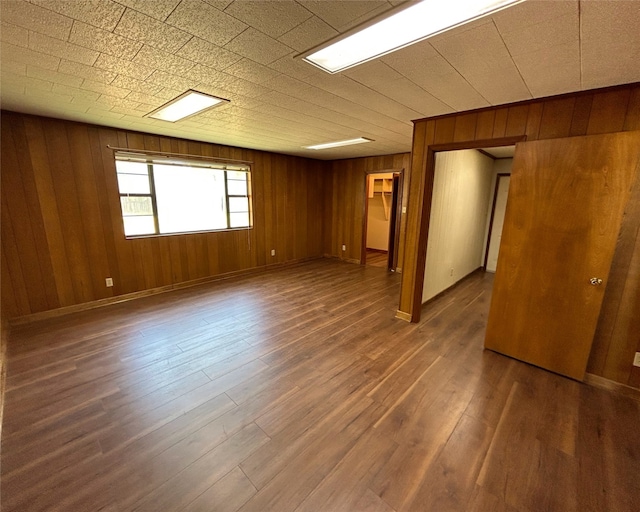 empty room featuring dark hardwood / wood-style floors and wooden walls