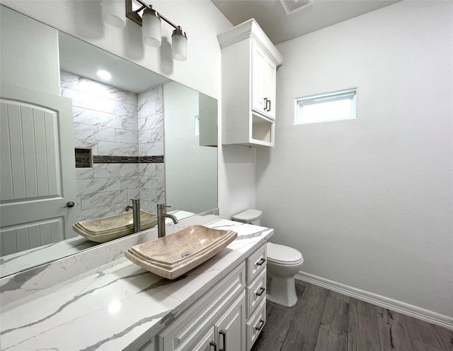 bathroom with toilet, vanity, and hardwood / wood-style flooring