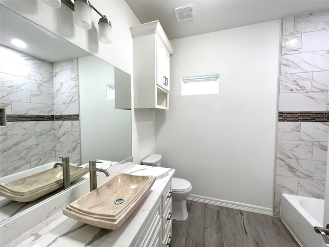 full bathroom with toilet, vanity, tiled shower / bath combo, and wood-type flooring