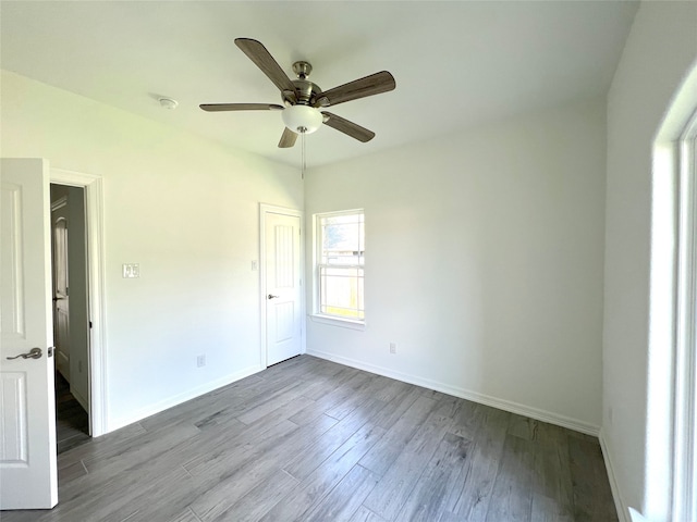 unfurnished room with ceiling fan and dark hardwood / wood-style flooring