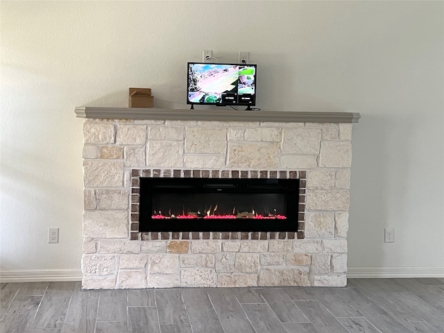 room details with hardwood / wood-style floors and a stone fireplace