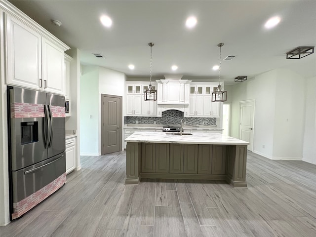 kitchen featuring white cabinetry, stainless steel refrigerator with ice dispenser, tasteful backsplash, and pendant lighting