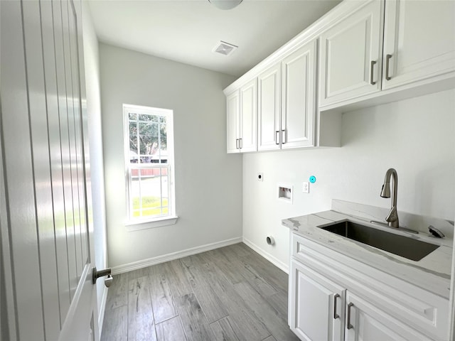 washroom featuring washer hookup, sink, electric dryer hookup, light hardwood / wood-style flooring, and cabinets