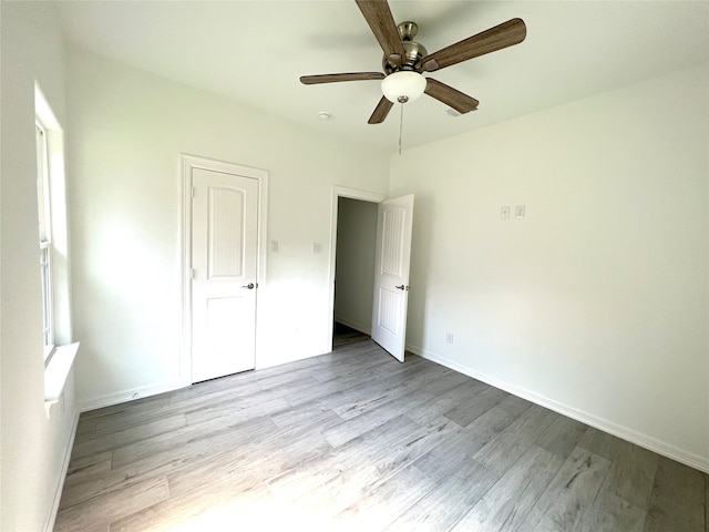 unfurnished bedroom with ceiling fan and light wood-type flooring