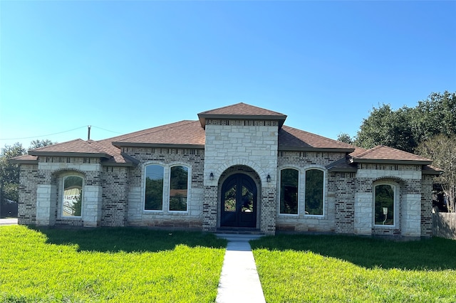 view of front of property with a front yard and french doors