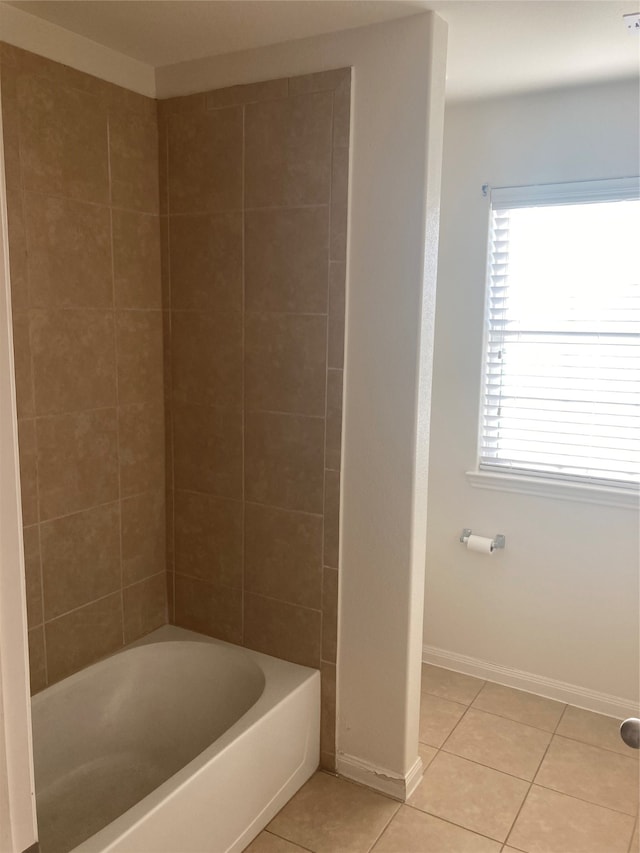 bathroom with tiled shower / bath combo, tile floors, and plenty of natural light