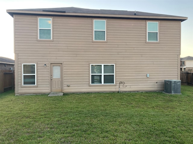 back of house featuring central AC and a yard