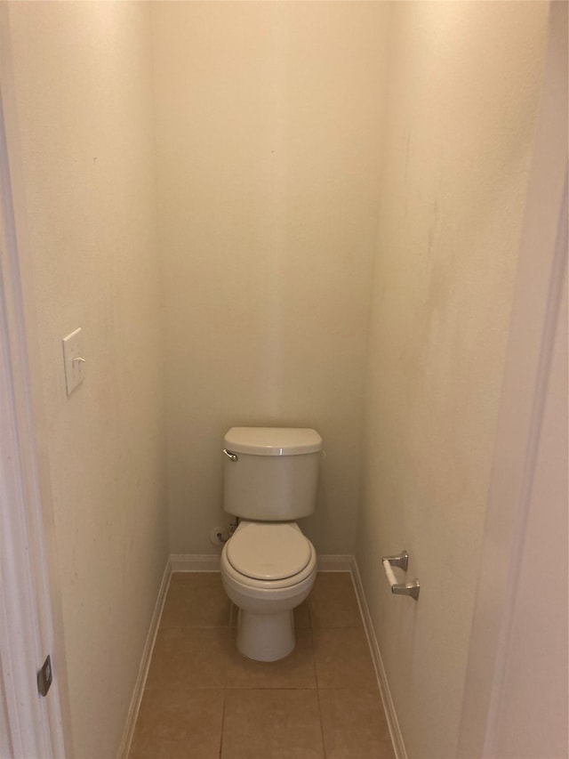 bathroom with toilet and tile floors