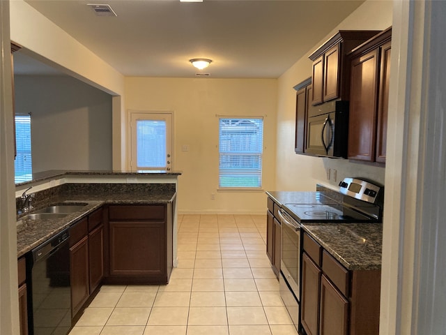 kitchen with light tile floors, dark stone counters, black appliances, and sink