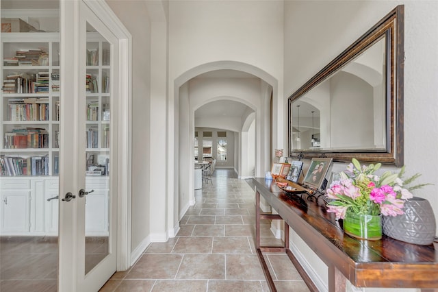 hall with french doors and light tile floors