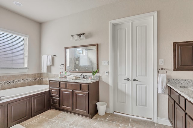 bathroom featuring a bath, tile flooring, and vanity with extensive cabinet space