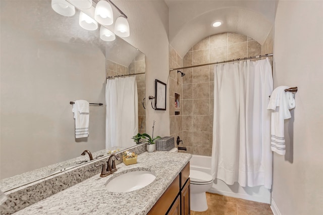 full bathroom with toilet, large vanity, shower / bath combo with shower curtain, vaulted ceiling, and tile flooring