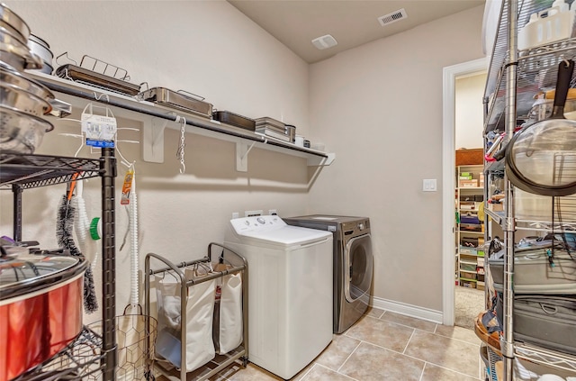 washroom featuring washing machine and clothes dryer and light tile flooring