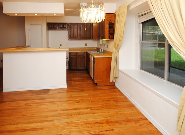 kitchen featuring a chandelier, pendant lighting, light hardwood / wood-style floors, dark brown cabinets, and sink