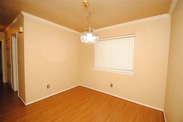 empty room with dark hardwood / wood-style floors, ornamental molding, and a notable chandelier