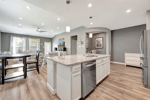 kitchen featuring sink, white cabinetry, hanging light fixtures, appliances with stainless steel finishes, and a kitchen island with sink