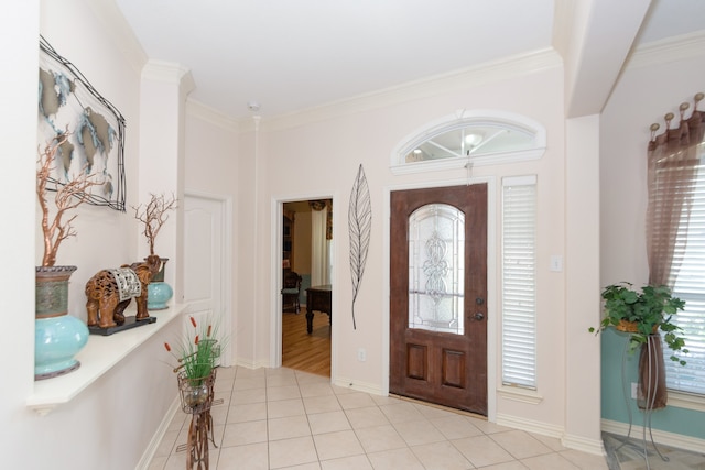 foyer with crown molding and light tile floors