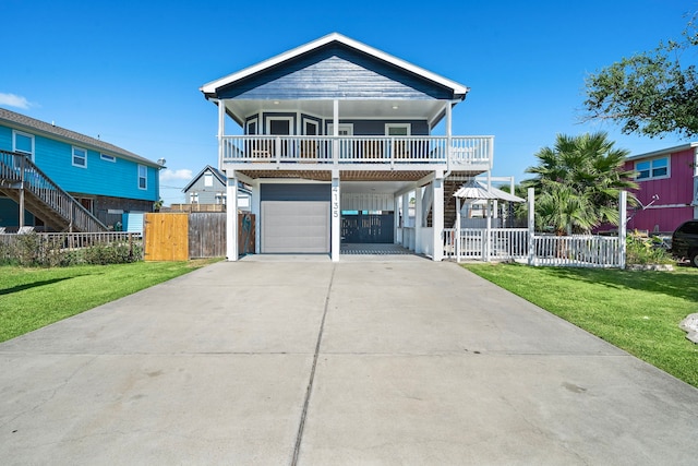 beach home with a balcony, a front lawn, and a garage