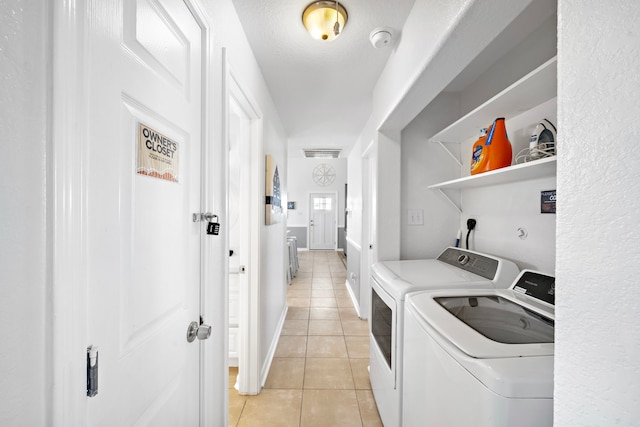 laundry area featuring light tile flooring and washing machine and dryer