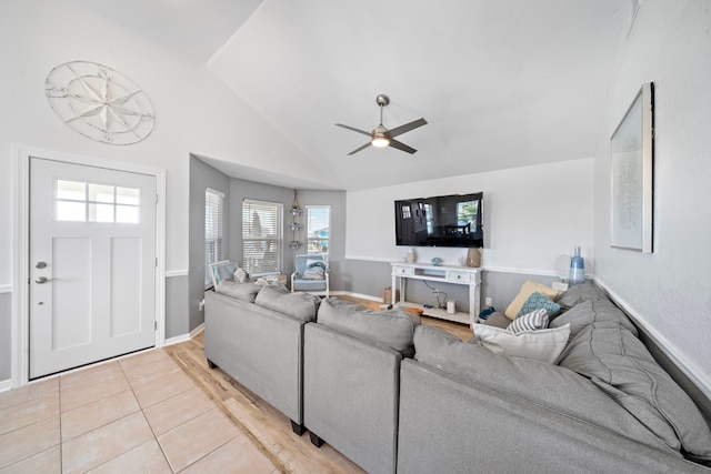 tiled living room with ceiling fan and vaulted ceiling