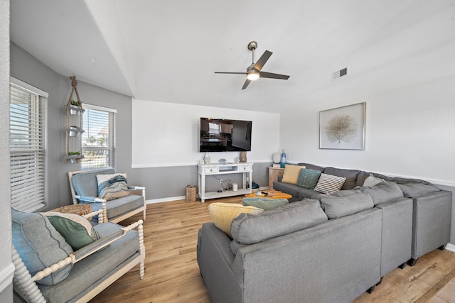 living room featuring ceiling fan, lofted ceiling, and light wood-type flooring