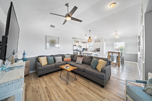 living room with ceiling fan, lofted ceiling, and light hardwood / wood-style floors