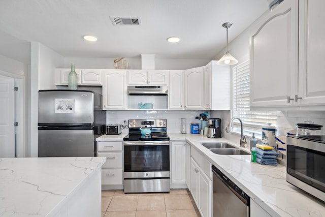 kitchen featuring white cabinets, appliances with stainless steel finishes, decorative light fixtures, and light stone counters