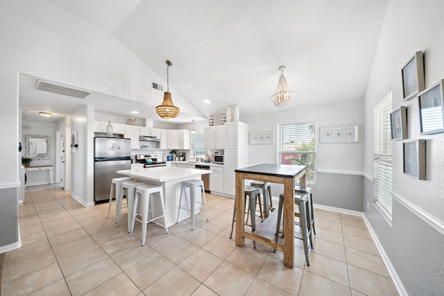 tiled dining room with a notable chandelier and high vaulted ceiling