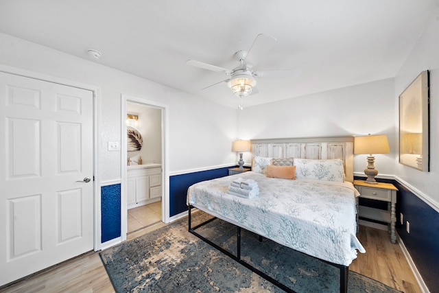 bedroom with connected bathroom, light hardwood / wood-style floors, and ceiling fan