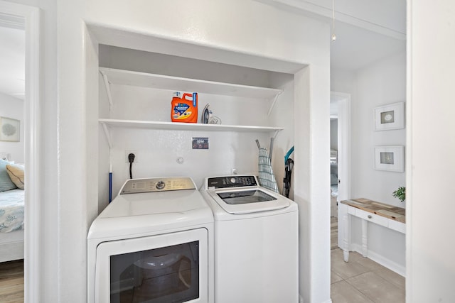 laundry room featuring light tile flooring and washing machine and dryer