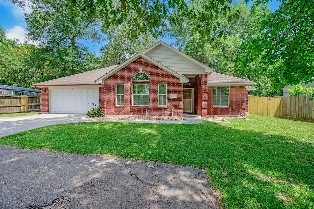 view of front of property with a front yard and a garage