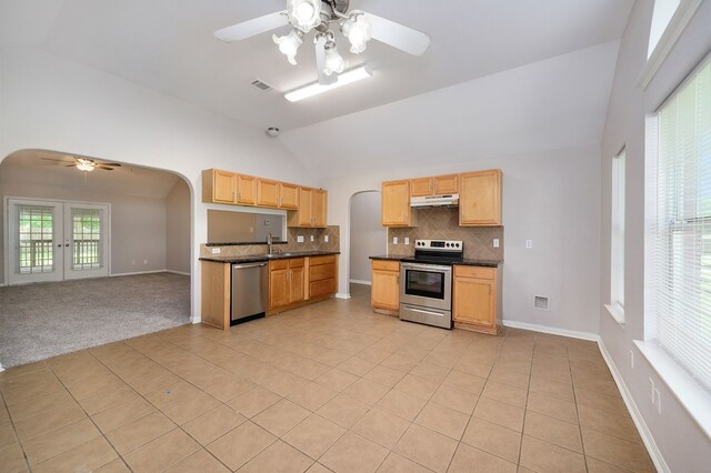 kitchen with stainless steel appliances, light tile floors, ceiling fan, tasteful backsplash, and dark stone countertops